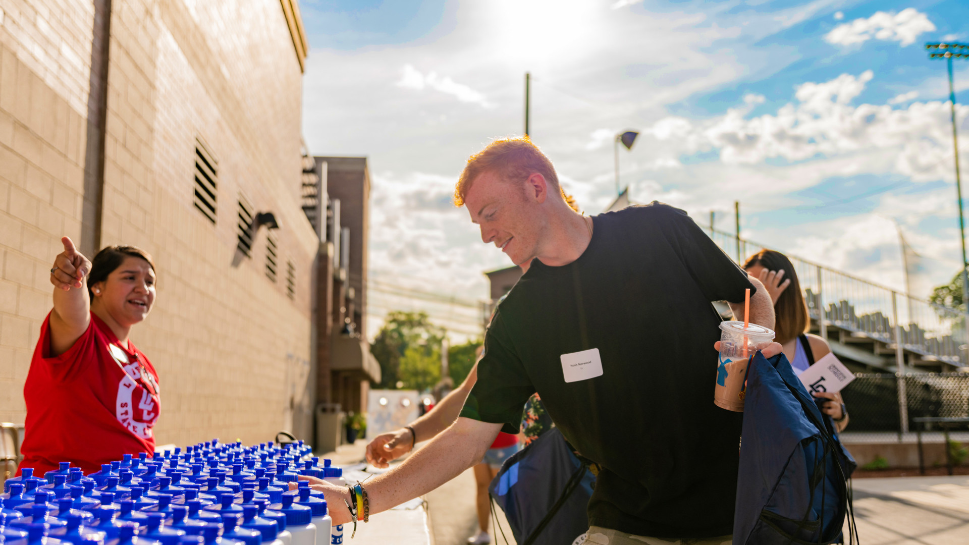 Male student picking up a waterbottle